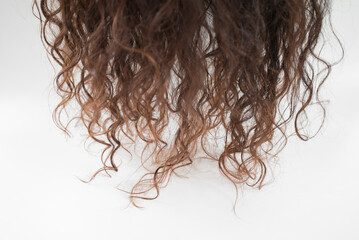 Naklejka premium wavy brown hair on a white background close-up, studio