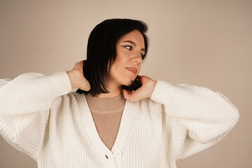 A woman in a cozy white sweater has her eyes gently closed