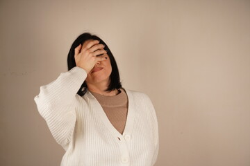 The woman touches her temple with one hand, signaling the agony of a bad headache. Her posture...