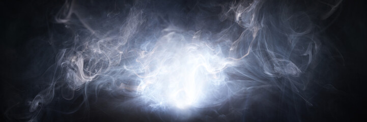 Abstract smoke texture over black background. Fog in the darkness.