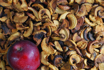 dried sliced ​​apples of various varieties with a whole red apple
