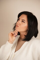A calm pose, symbolizing mindfulness and reflection. A young woman places her hand under her chin,...
