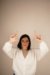 The young woman points in one direction with both index fingers, clearly indicating a path. Her posture is confident and expressive. A gesture full of purpose and clarity.