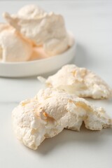 Delicious homemade meringue cookies on light table, closeup