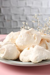 Delicious homemade meringue cookies on pink table, closeup