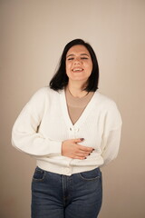 The joyful expression on her face conveys pure happiness and warmth. This gesture emphasizes her carefree and cheerful nature. A woman raises her hands, showing the backs of her fingers.