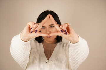 This gesture is a universal symbol for peace and understanding, often used to convey a message of goodwill and balance. The fingers forming the peace sign represent harmony and unity.