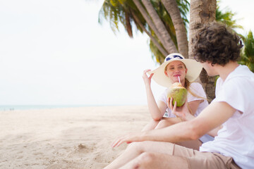 A Caucasian couple relaxing under the coconut tree at the beach.