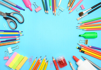 Fototapeta premium Flat lay of colorful school stationery arranged in a circle on blue background with empty space for text. Perfect for back to school banners or educational ads.