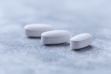 Amino acids tablets on wooden background. Soft focus. Close up