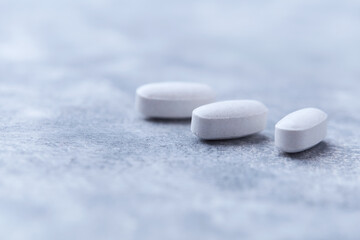 Amino acids tablets on wooden background. Soft focus. Close up