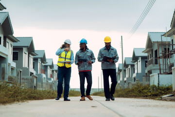 Construction engineers and crews discuss site preparation plans for solar panel installation and system setup for an energy-efficient home project while walking around the project.