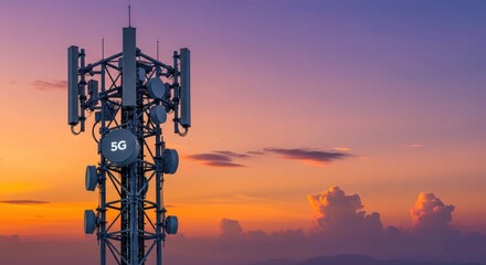 Telecommunication tower against a colorful sunset sky with clouds in the background.