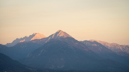 Mountain peaks catching warm orange light during the sunset , Bled, Slovenia