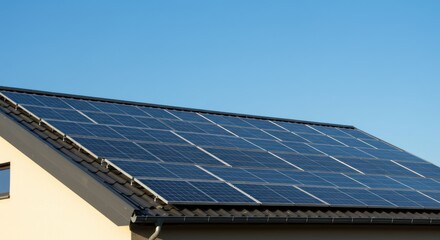 Solar panels on a roof against a clear blue sky.