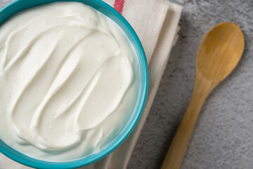 Top view of yogurt in bowl on grey stone table. Healthy eating concept