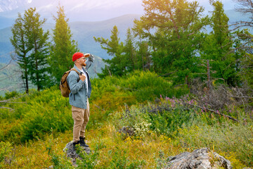 Young man traveler with backpack exploring beautiful Altay mountains trip to base camp