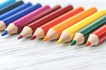 Fototapeta premium Set of colored pencils arranged in a gradient on a wooden surface for artistic inspiration and creativity