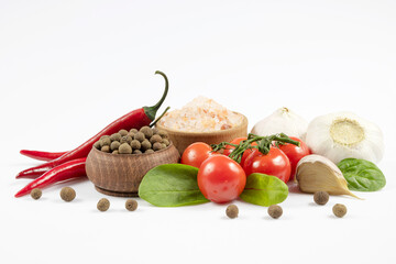 Fresh vegetables, salt and seasonings in large pan isolated on white background.