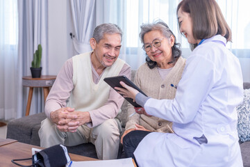 young female professional doctor giving consultation asian senior couple with using tablet computer in the room,selective focus at elderly couple