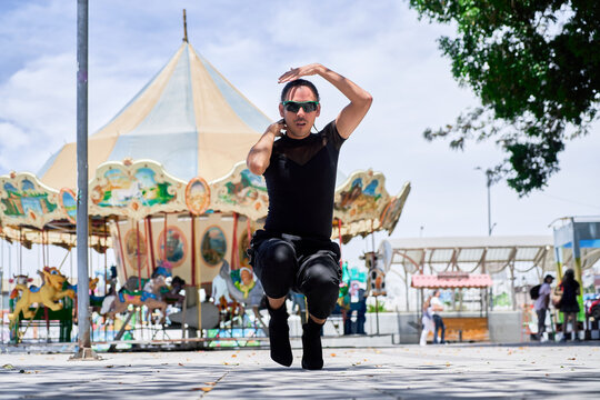 Young LGBT dancer performing vogue choreography on city street