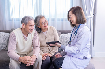 young female professional doctor giving consultation asian senior couple with using tablet computer...