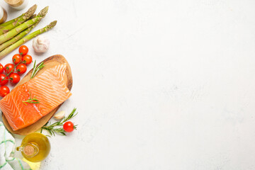 Salmon fillet with fresh vegetables on white background.