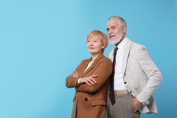Lovely senior couple on light blue background. Space for text