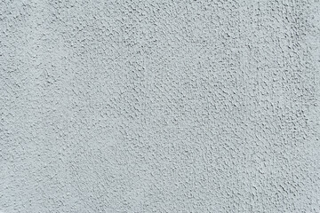 Close-up, background texture of a beige-white facade wall of a house made of decorative plaster. Abstract surface.