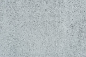 Close-up, background texture of a beige-white facade wall of a house made of decorative plaster. Abstract surface.