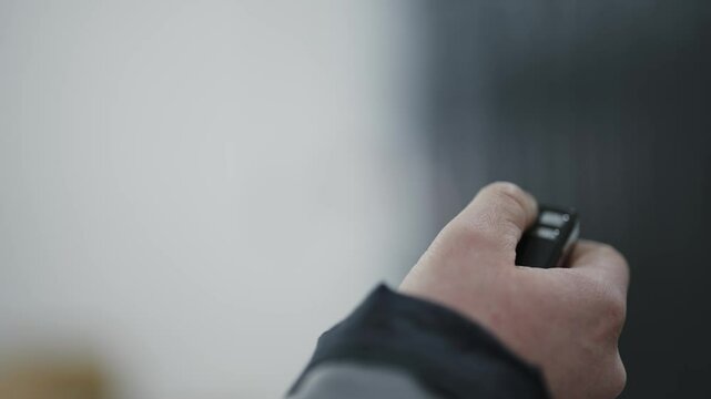 Person operating a remote control opening a garage or security gate