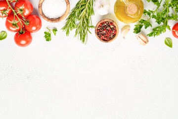 Spices, herbs and vegetables with olive oil on white kitchen table.