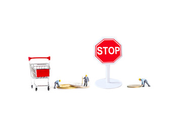 miniature worker with stop sign and shopping cart isolated on white background.