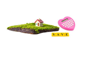 miniature house with red roof on green grass isolate on white background