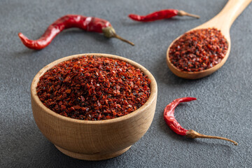 Red pepper flakes.Red chili peppers in wooden bowl on black background.Dried chili peppers
