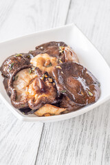Crispy fried garlic thyme shiitake mushrooms nestled in a white bowl