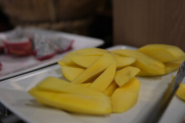 Fresh and ripe mango fruit slice on wooden bowl . High quality photo