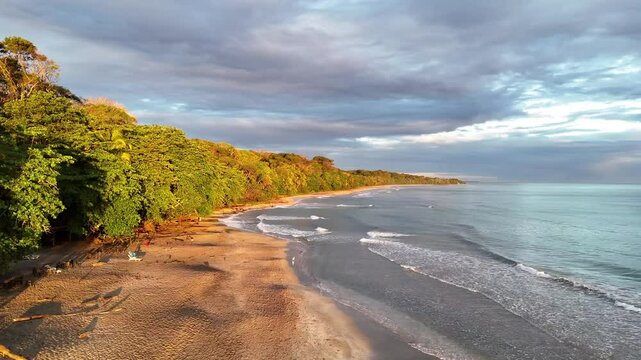 Flug entlang einer K&uuml;stenlinie mit Sandstrand und Urwald im warmen Morgenlicht