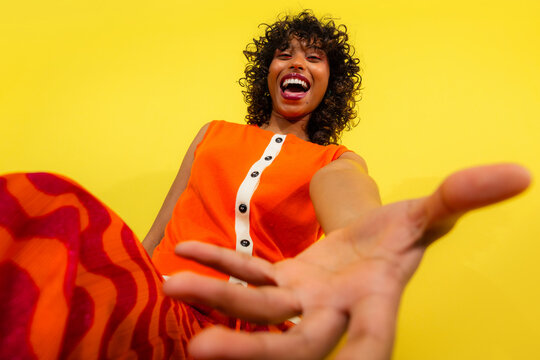 Bright and joyful woman reaching out with a smile
