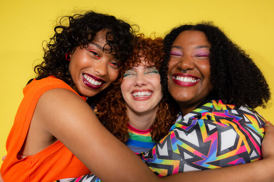 Smiling women embrace in colorful clothing