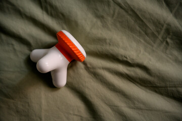 Electric head massager resting on bed sheets promoting relaxation and pain relief