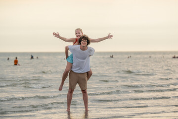 Full body.  young lovely couple two friends family man woman in casual clothes hold hands walking stroll together at sunrise over sea beach ocean outdoor exotic seaside in summer day evening.