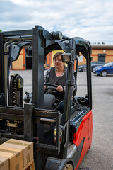 A woman is driving a forklift truck