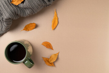 Cup of tea with leaves on beige background. Flat lay, top view. Copy space