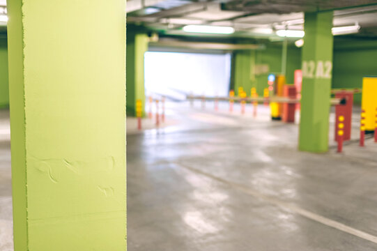The background of an empty underground parking lot is green with a barrier. - Powered by Adobe
