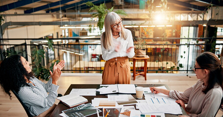 Creative paperwork, women and applause in meeting for marketing campaign success, KPI goals and...