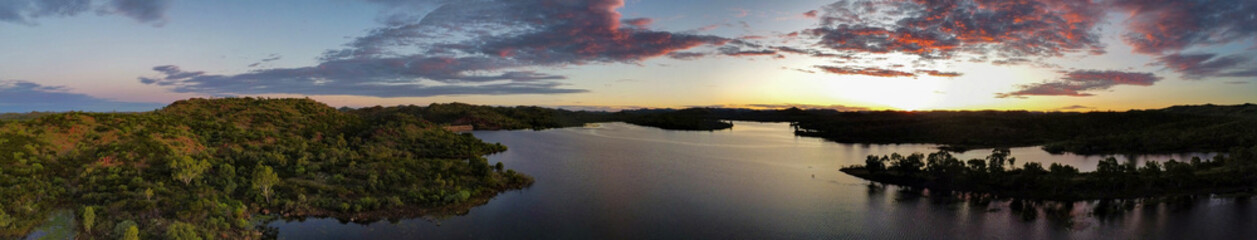 Fototapeta premium Sunset over a calm lake with mountains in the background, seen from above