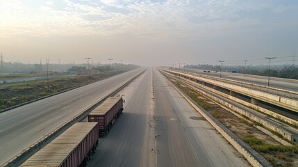 A service road parallel to a major highway with a few parked trucks