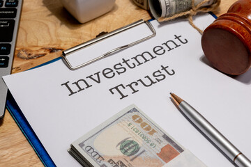 A financial document titled “Investment Trust” secured in a clipboard, resting on a clean...