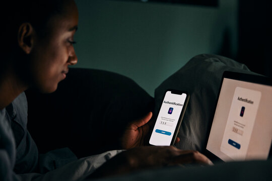 Woman using wireless technologies for authentication password in bedroom at night